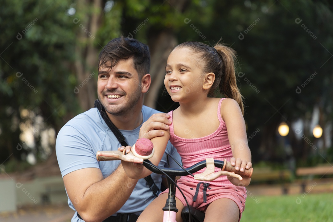 Um pai brincando com sua filha no parque