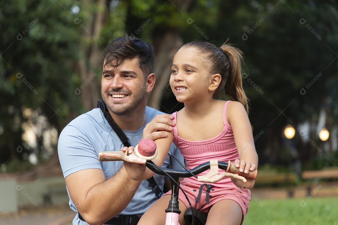 Um pai brincando com sua filha no parque