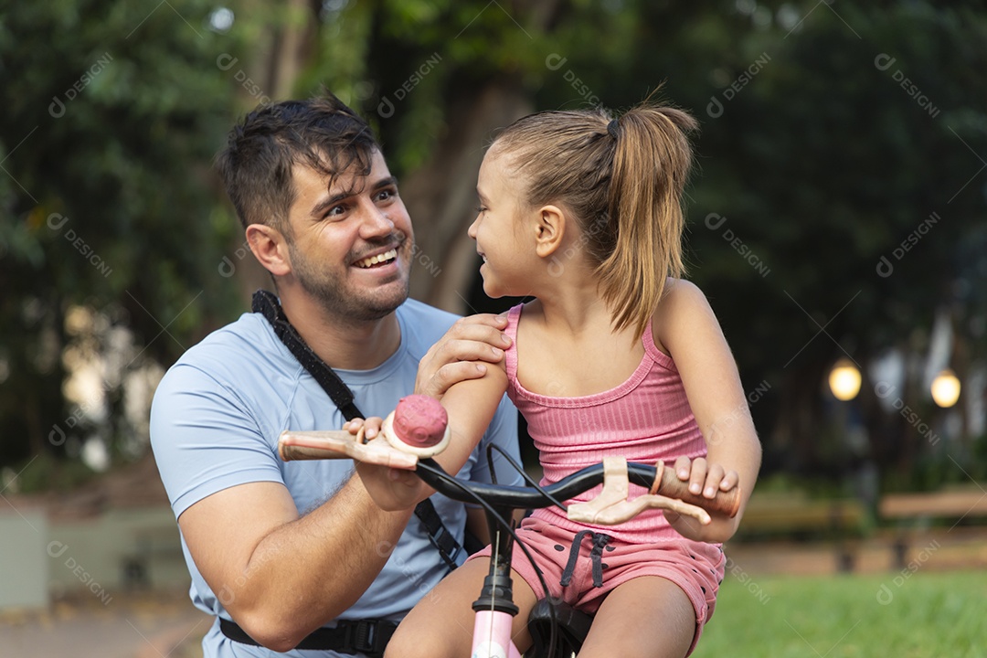 Um pai brincando com sua filha no parque