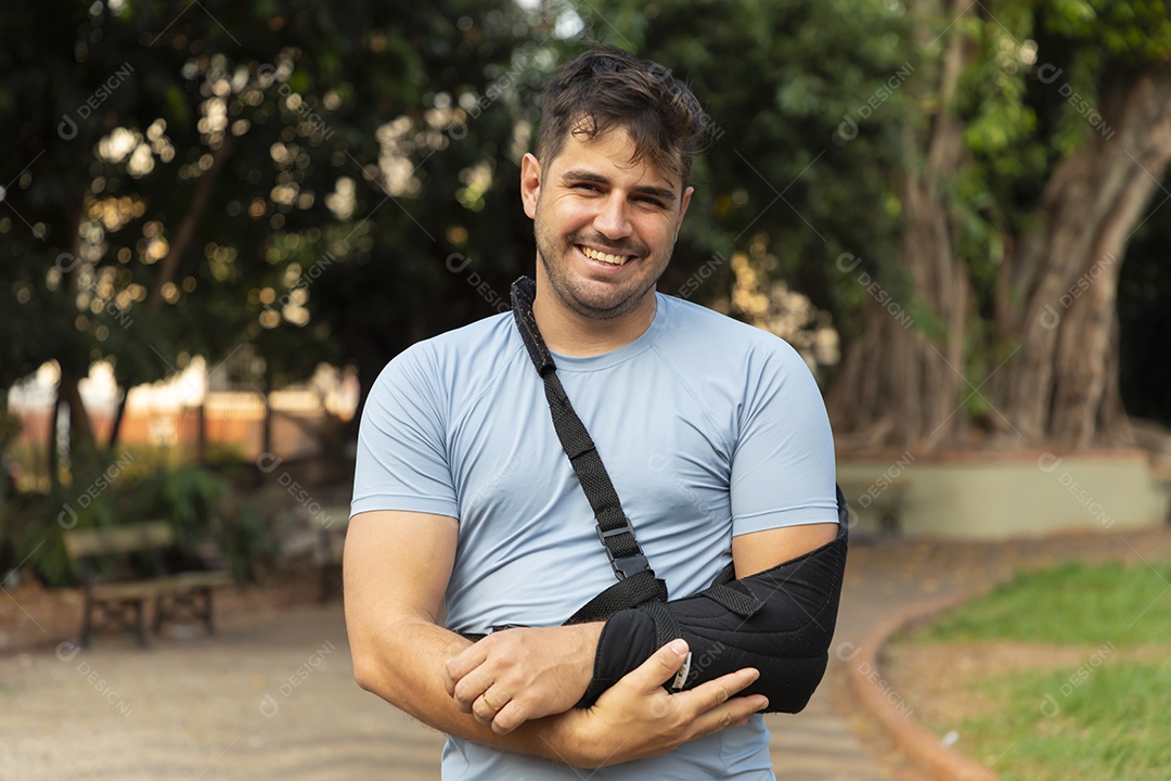 Homem sorrindo com braço na tipoia