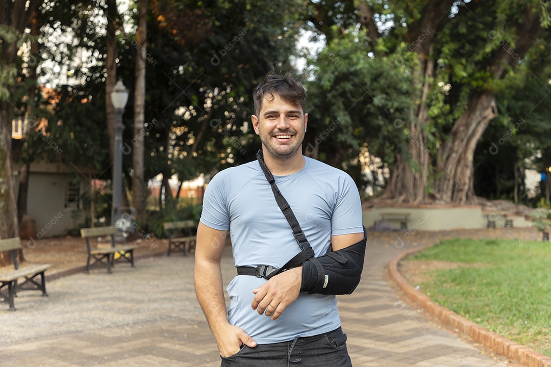 Homem sorrindo com braço na tipoia