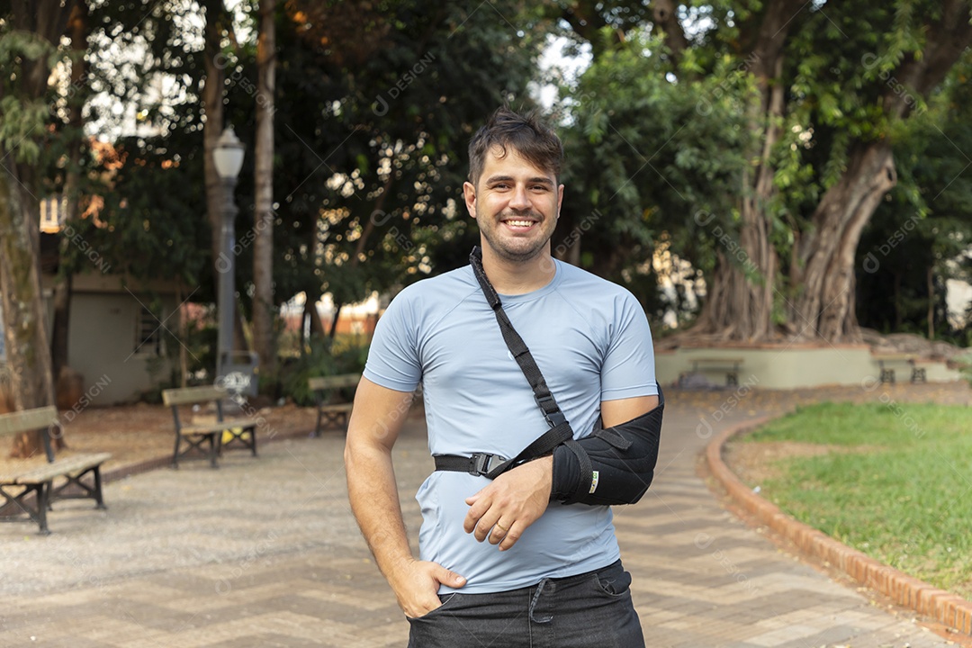 Homem sorrindo com braço na tipoia