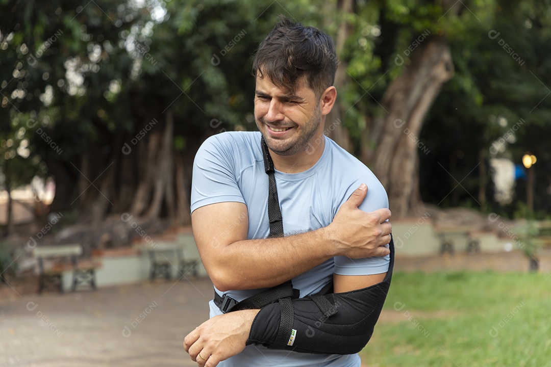 Homem com braço machucado usando tipoia