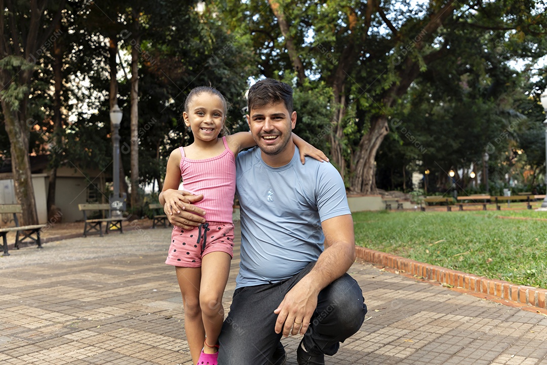 Linda menina abraçando seu pai no parque