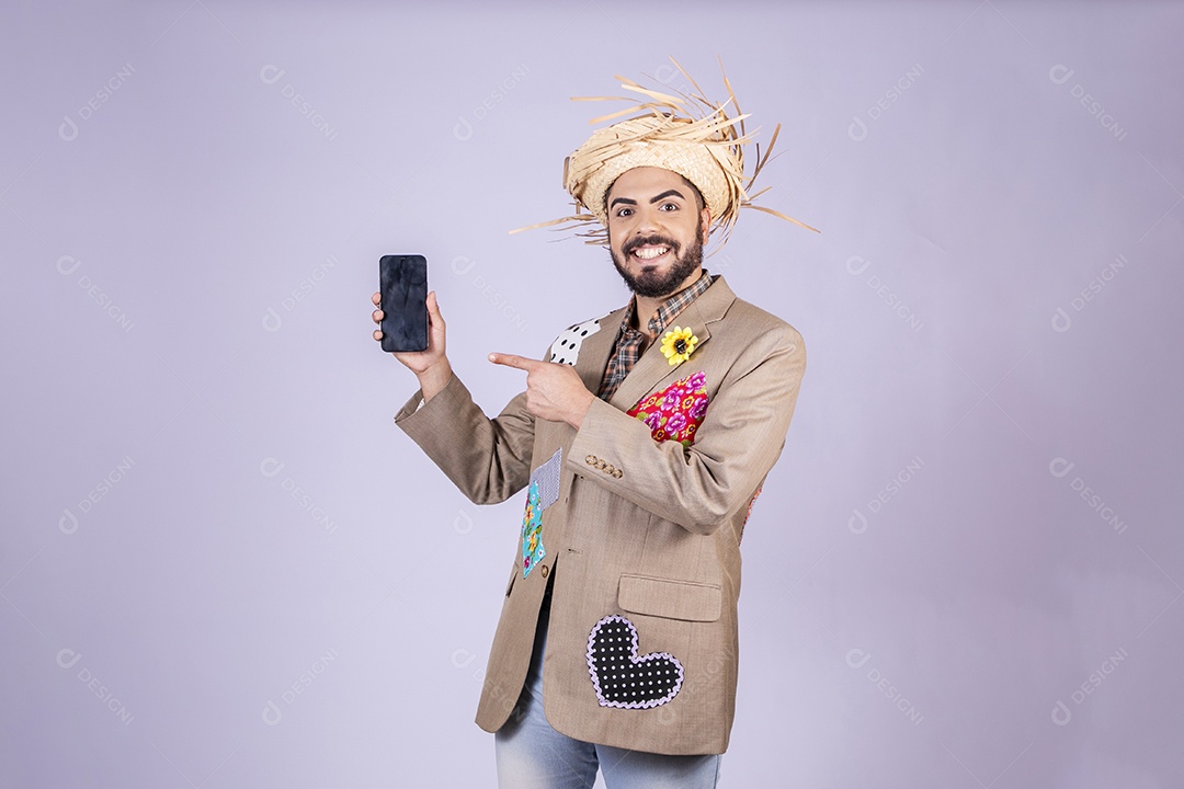 Jovem rapaz trajado para festa junina com celular na mão e apontando