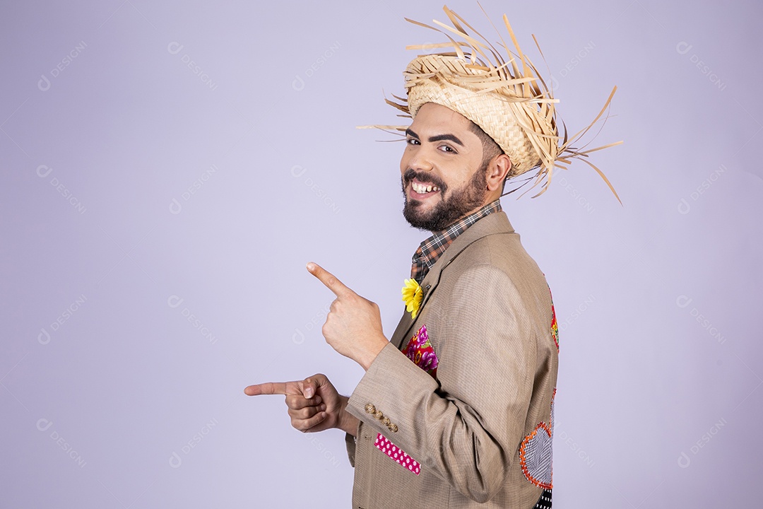 Jovem rapaz trajado para festa junina apontando para o lado