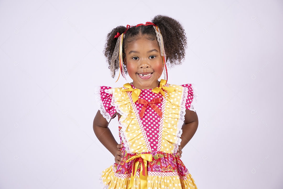 Linda garotinha trajada para festa junina com mãos na cintura e sorrindo