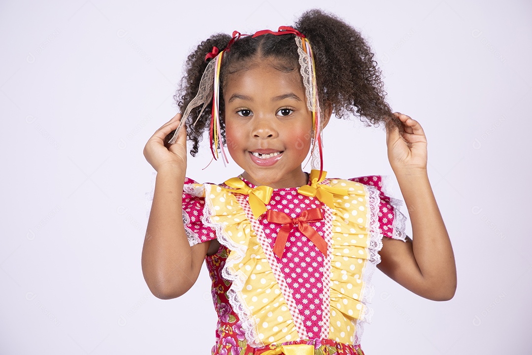Linda garotinha trajada para festa junina com mãos no cabelo e sorrindo