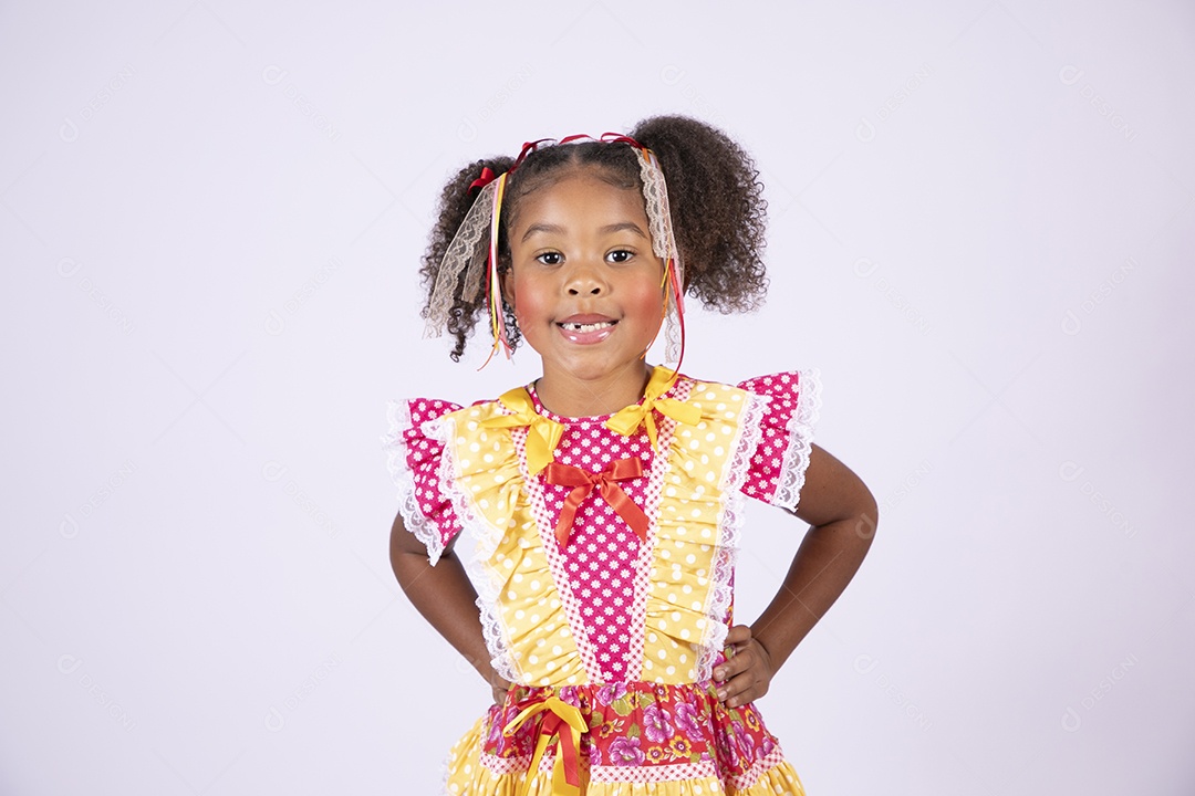 Linda garotinha trajada para festa junina com mãos na cintura e sorrindo