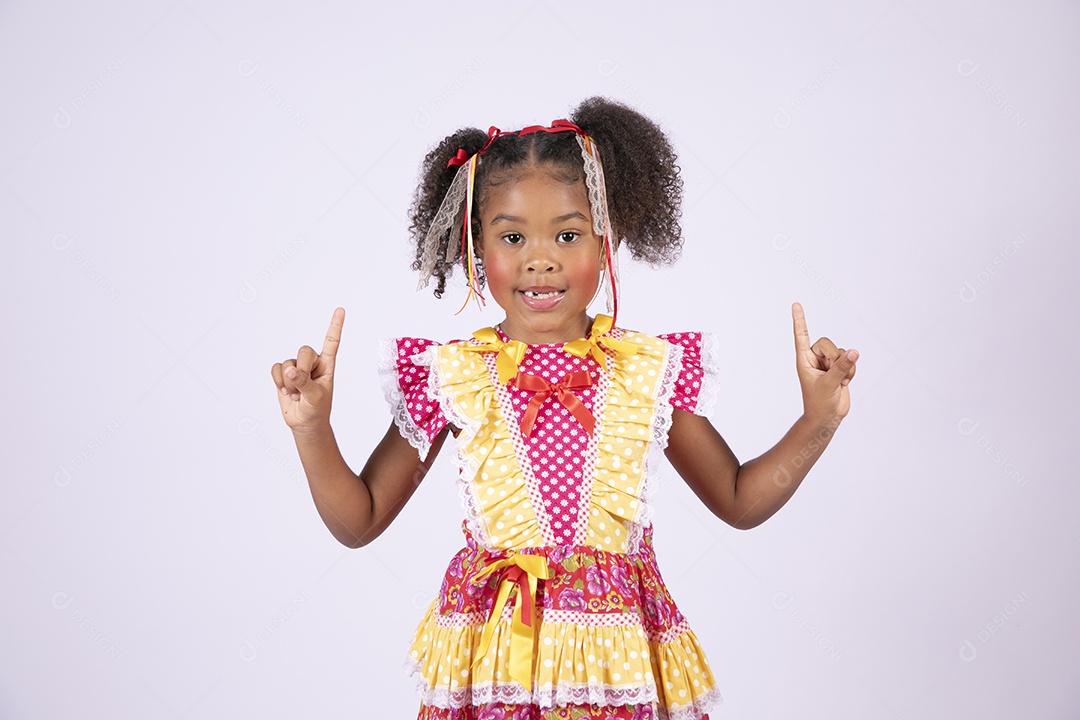 Linda garotinha trajada para festa junina apontando para cima