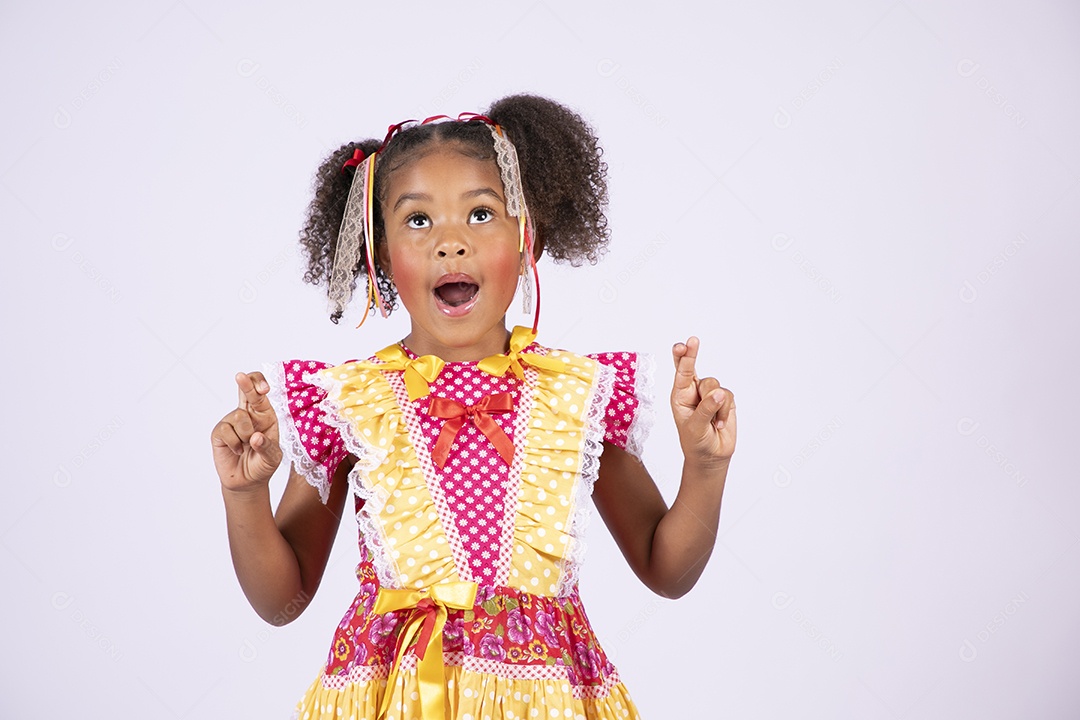 Linda quadrilheira mirim trajada fazendo pose olhando para cima e dedos cruzados