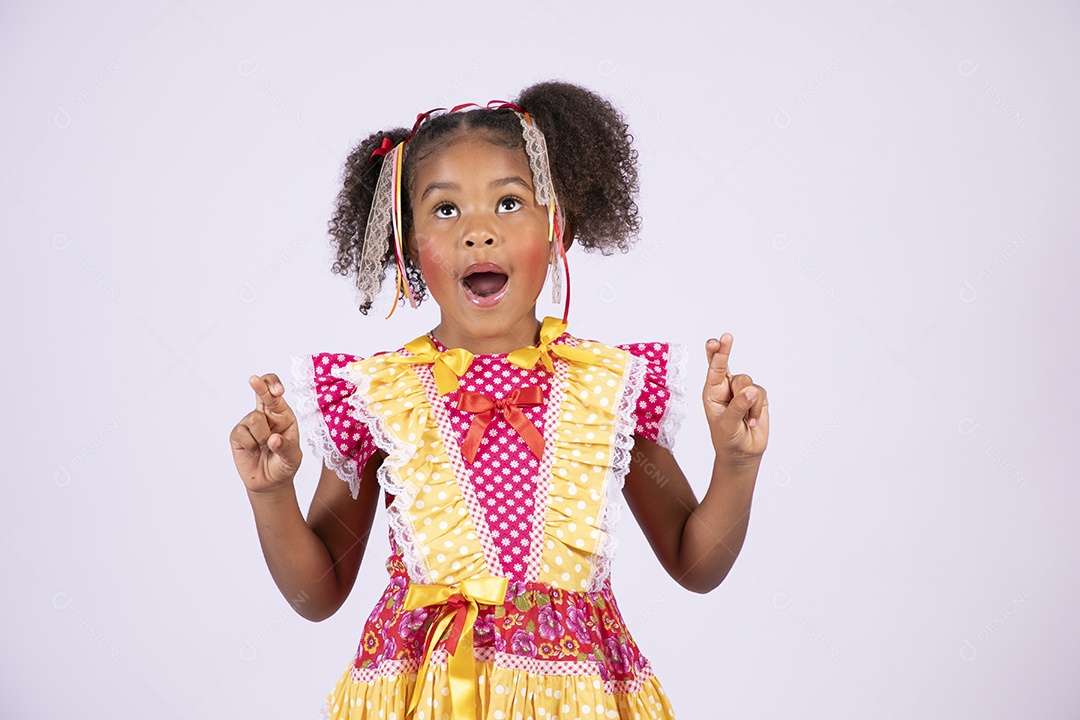 Linda quadrilheira mirim trajada fazendo pose olhando para cima e dedos cruzados
