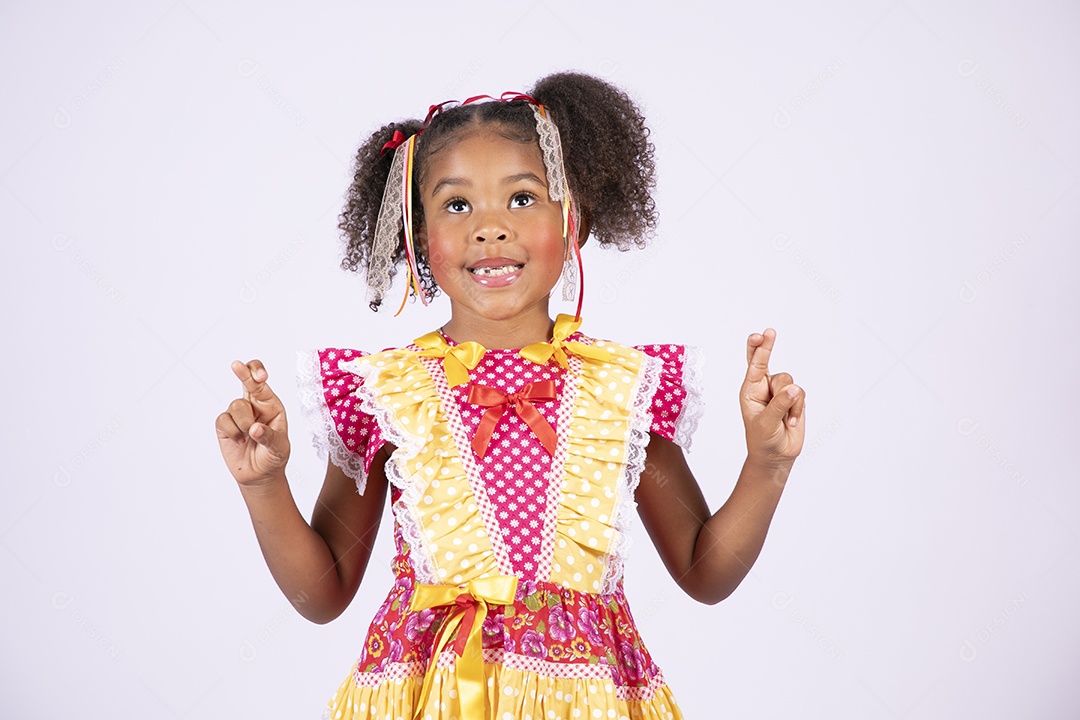 Linda quadrilheira mirim trajada fazendo pose olhando para cima e dedos cruzados