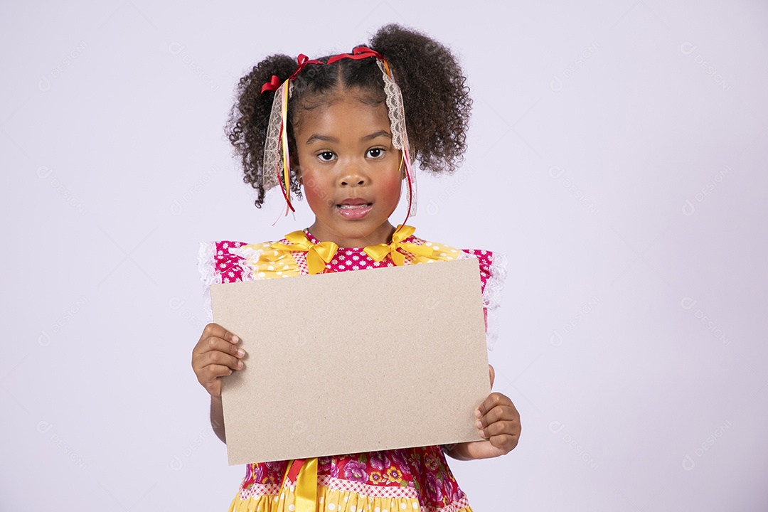 Quadrilheira mirim com plaquinha na mão e sorrindo