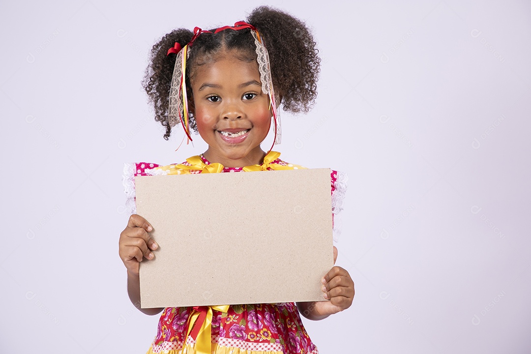 Quadrilheira mirim com plaquinha na mão e sorrindo