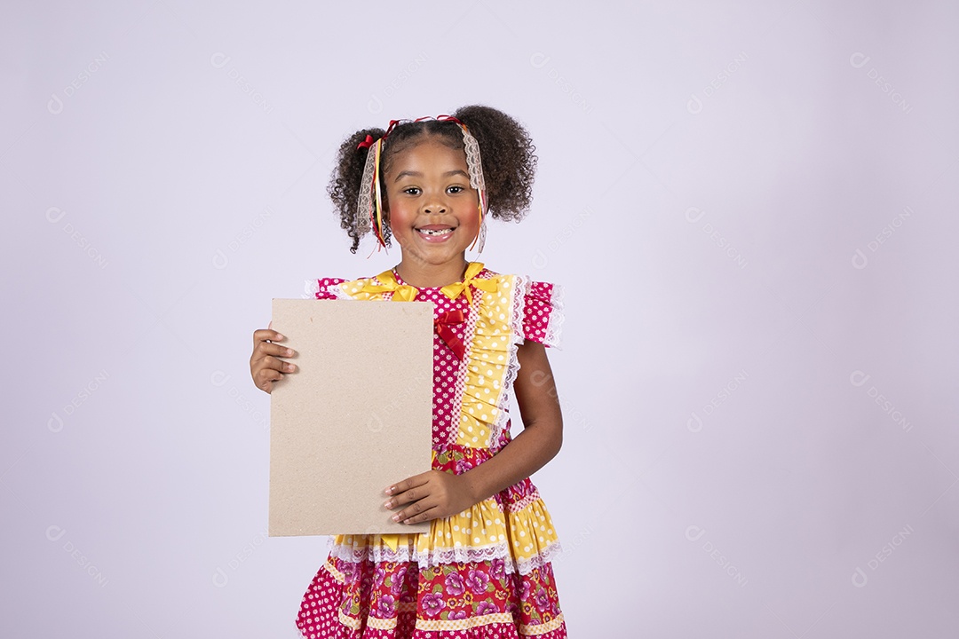 Quadrilheira mirim com plaquinha na mão e sorrindo