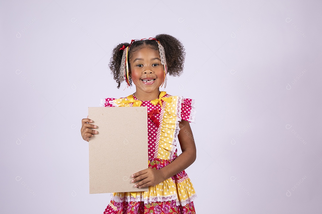 Quadrilheira mirim com plaquinha na mão e sorrindo