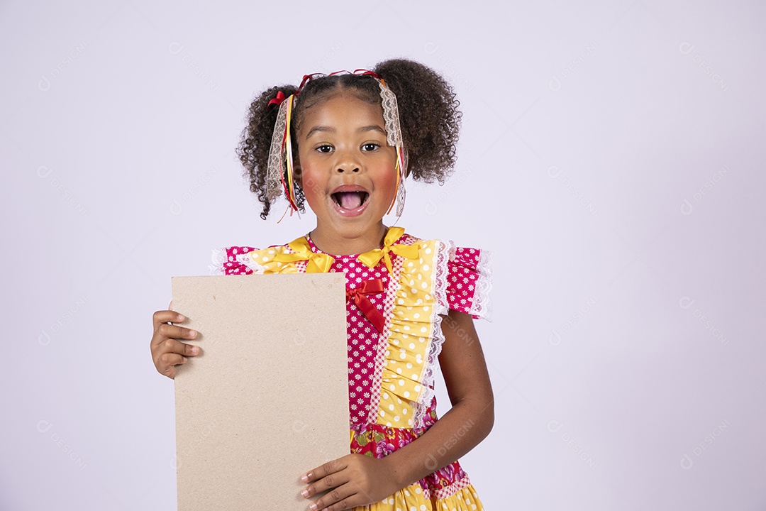 Quadrilheira mirim com plaquinha na mão e sorrindo