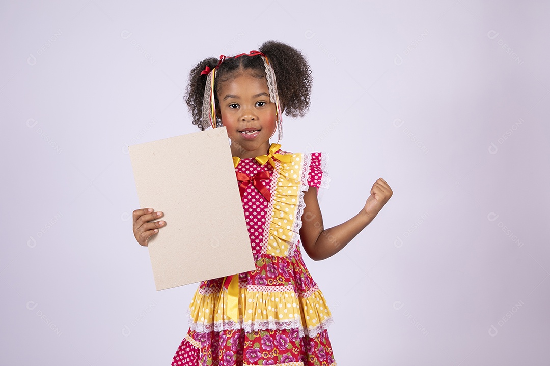 Quadrilheira mirim com plaquinha na mão e sorrindo