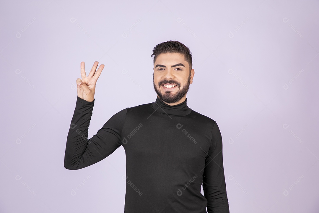 Homem fazendo gesto de três dedos para cima e sorrindo