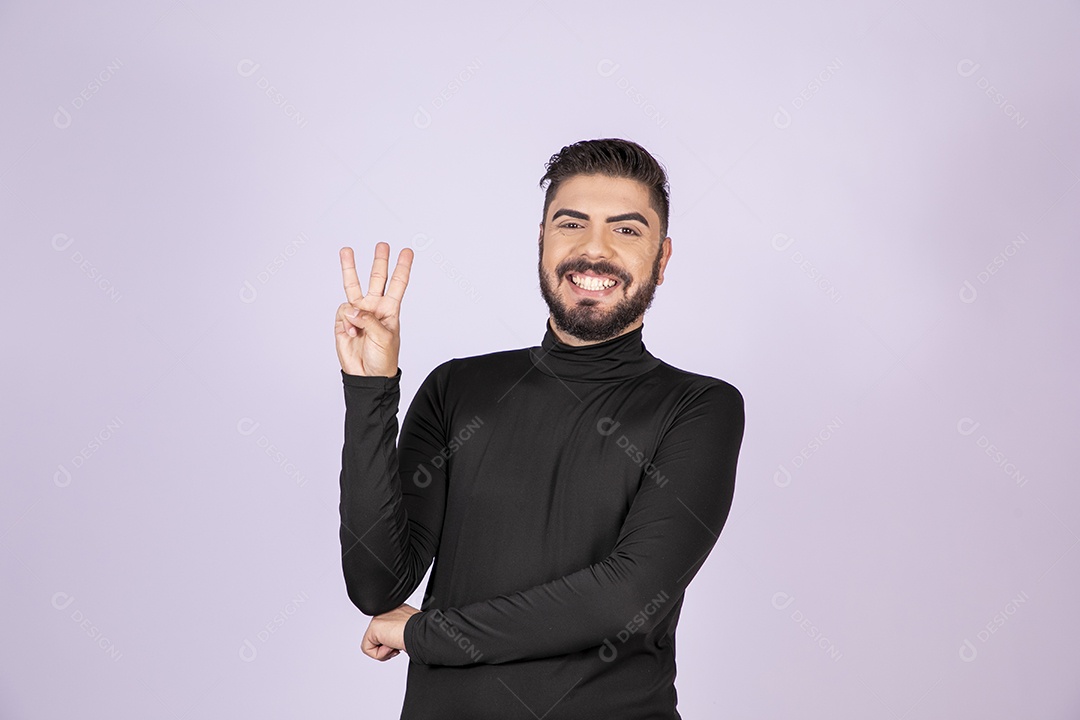 Homem fazendo gesto de três dedos para cima e sorrindo