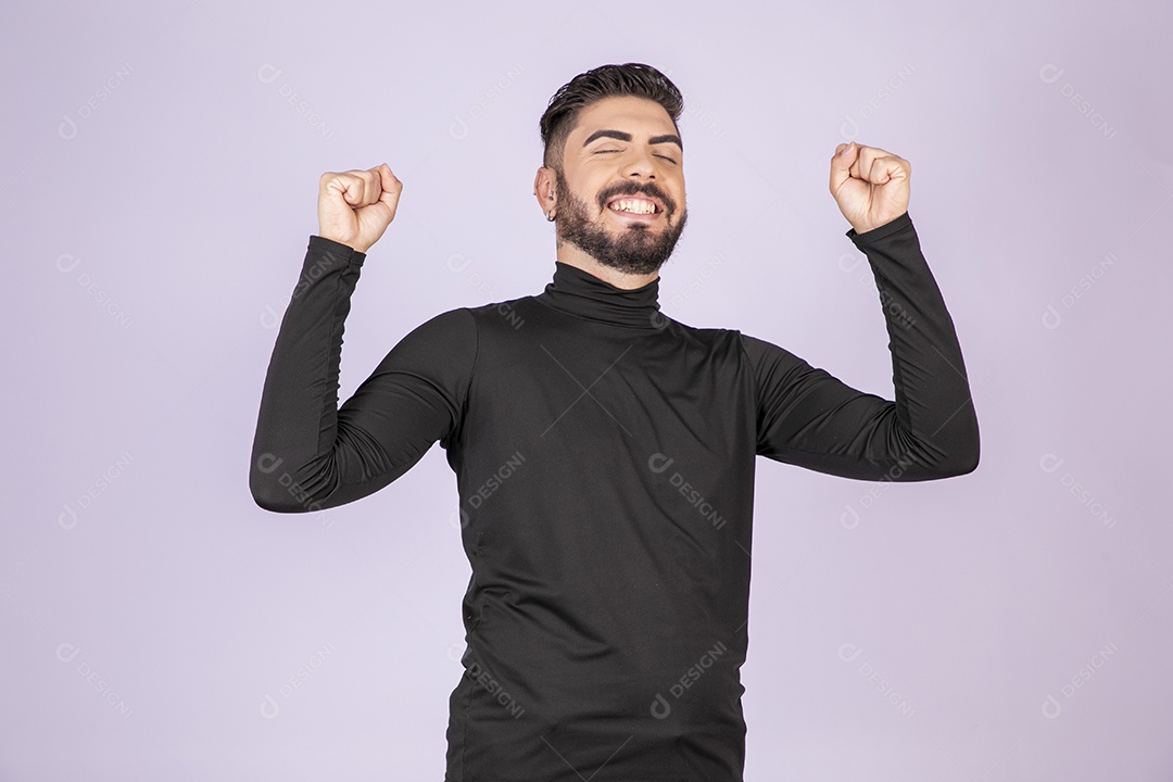 Jovem rapaz sorrindo e comemorando algo