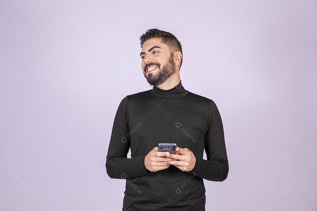 Homem feliz com seu celular nas mãos olhando para o lado