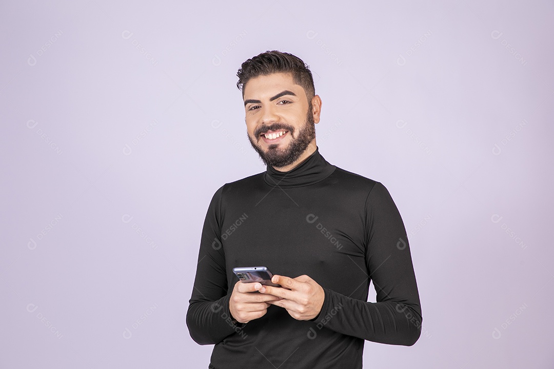 Homem sorridente com celular nas mãos