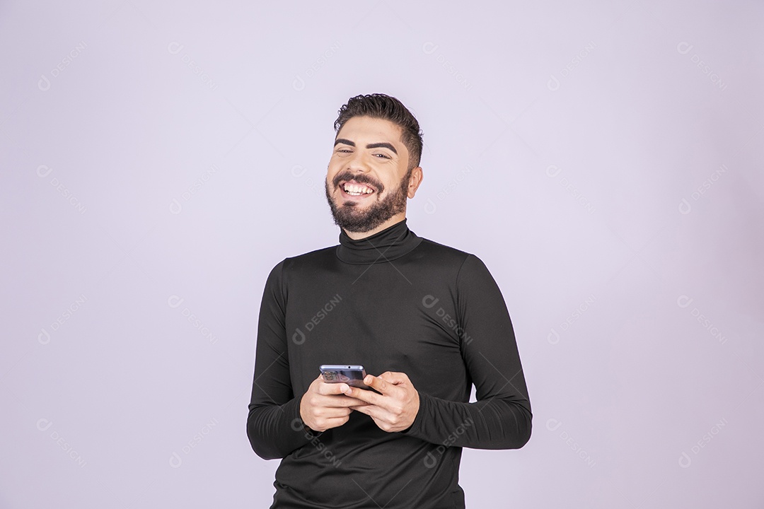 Homem sorrindo com celular nas mãos