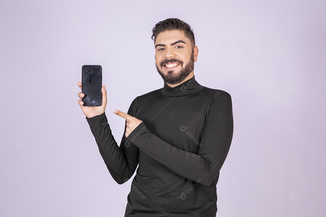 Homem feliz com celular na mão e apontando