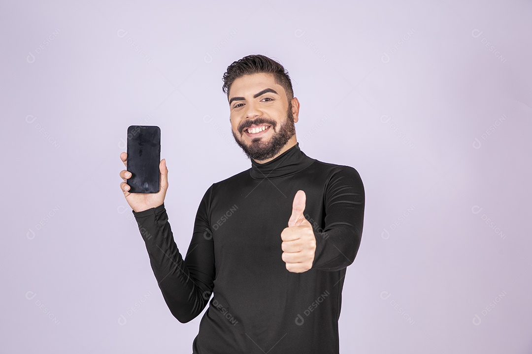 Homem sorrindo com celular nas mãos e gesto de ok