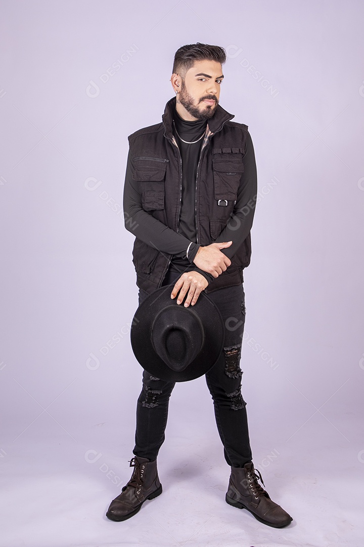 Homem charmoso com chapéu nas mãos