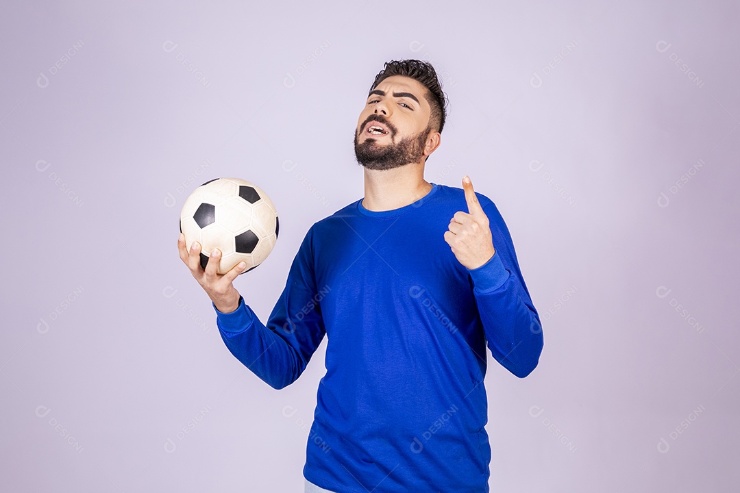 Homem com bola nas mãos apontando para cima