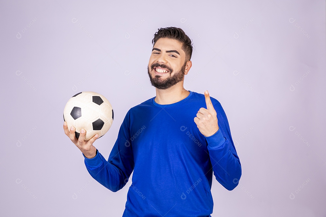 Homem com bola na mãos apontando para cima