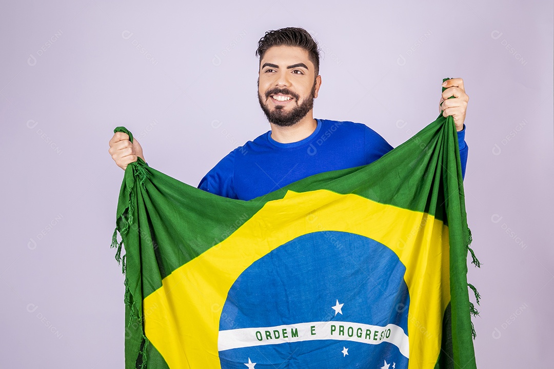 Homem sorrindo com bandeira do brasil nas mãos