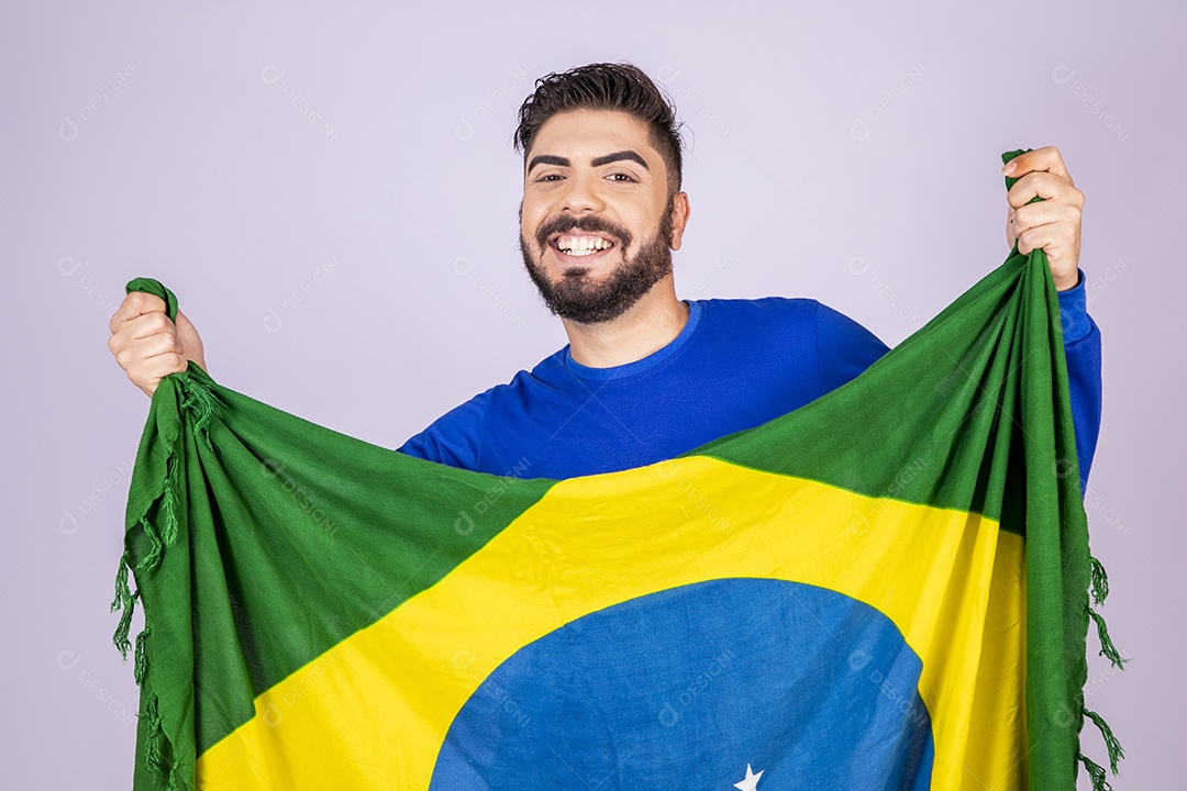 Homem sorrindo com bandeira do brasil nas mãos