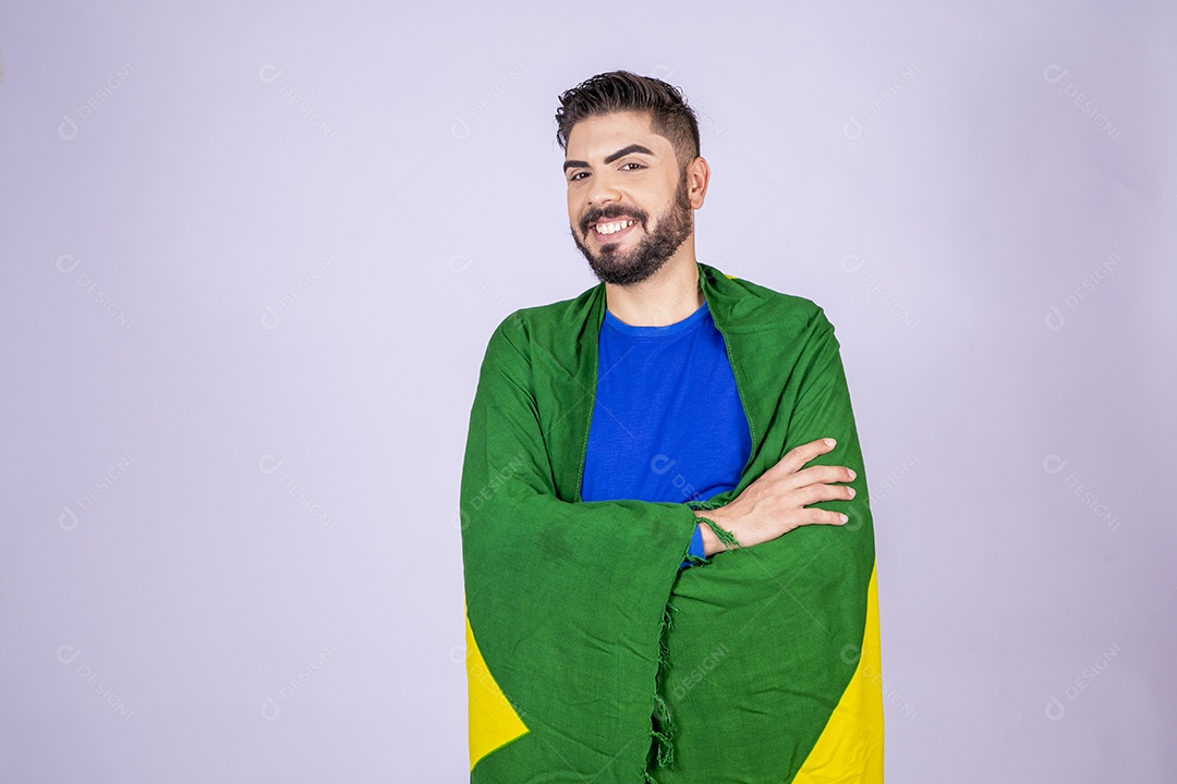 Homem sorrindo de braços cruzados com bandeira nas costas