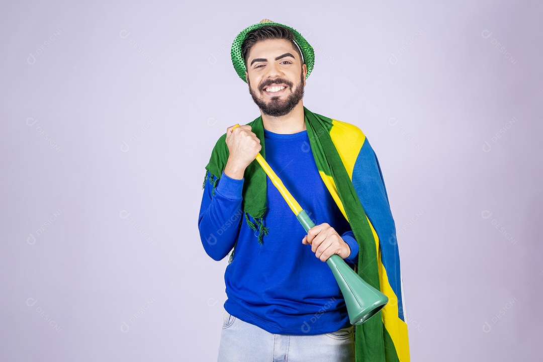 Homem simpático com bandeira nas costas com corneta nas mãos