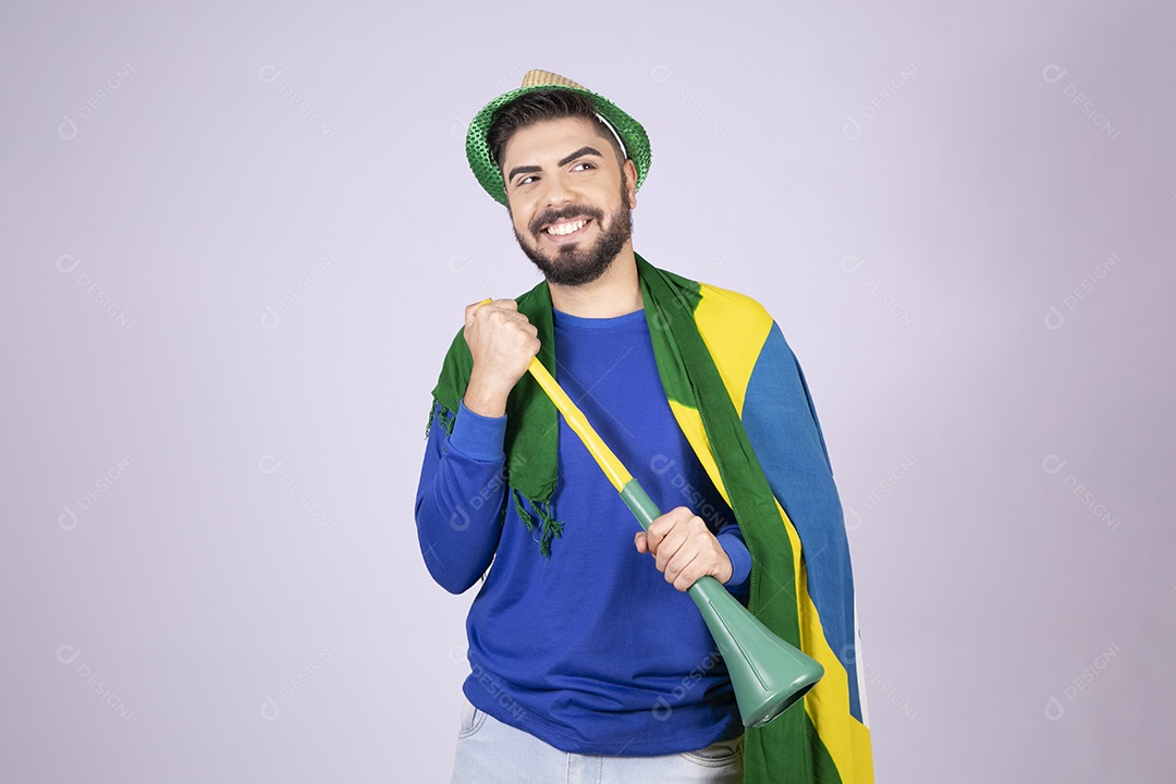 Homem sorrindo com bandeira e cornetão nas mãos