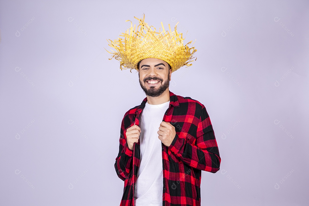 Jovem de xadrez com chapéu de palha sorrindo para festa junina