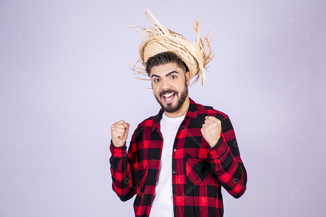 Jovem de xadrez com chapéu de palha torcendo para algo