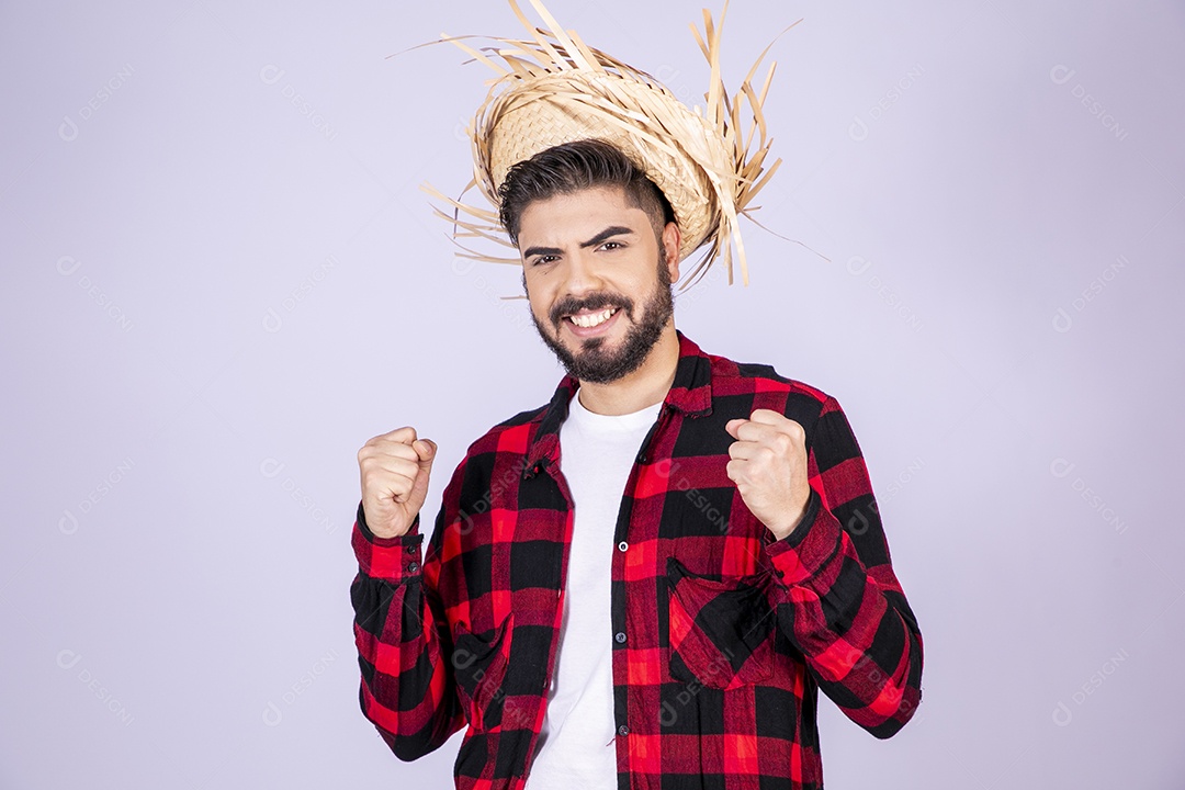 Jovem de xadrez com chapéu de palha torcendo para algo