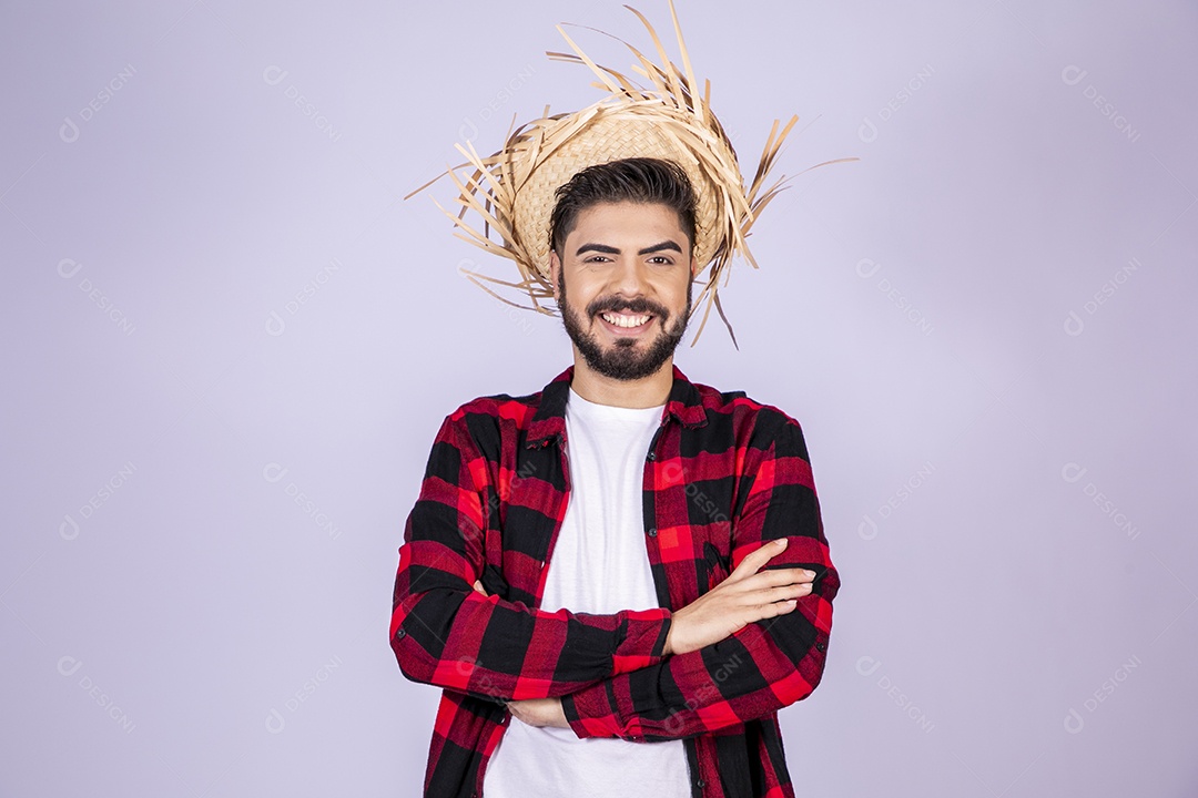 Jovem de xadrez com chapéu de palha sorrindo para festa junina