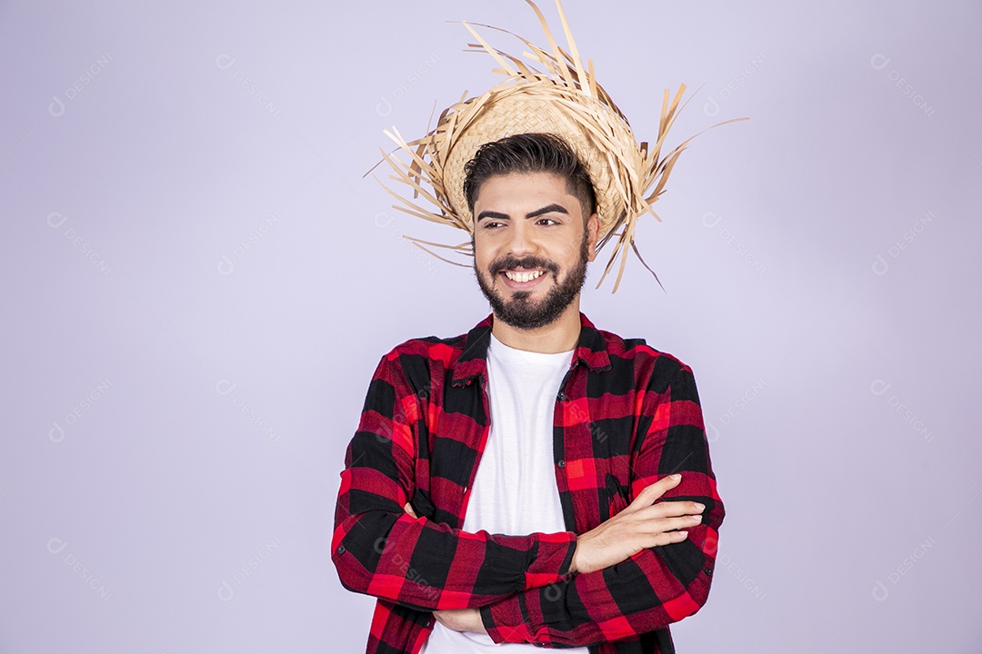 Jovem de xadrez com chapéu de palha sorrindo para festa junina