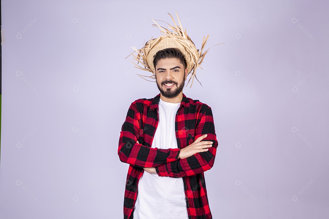Jovem de xadrez com chapéu de palha sorrindo para festa junina