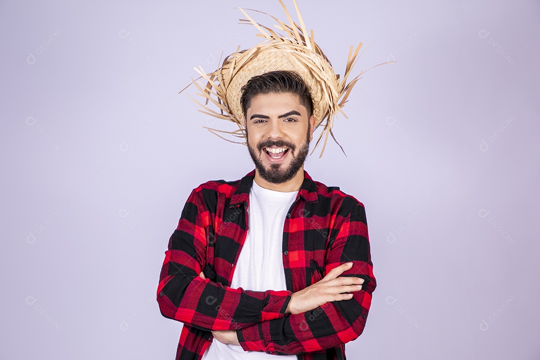 Jovem de xadrez com chapéu de palha sorrindo para festa junina