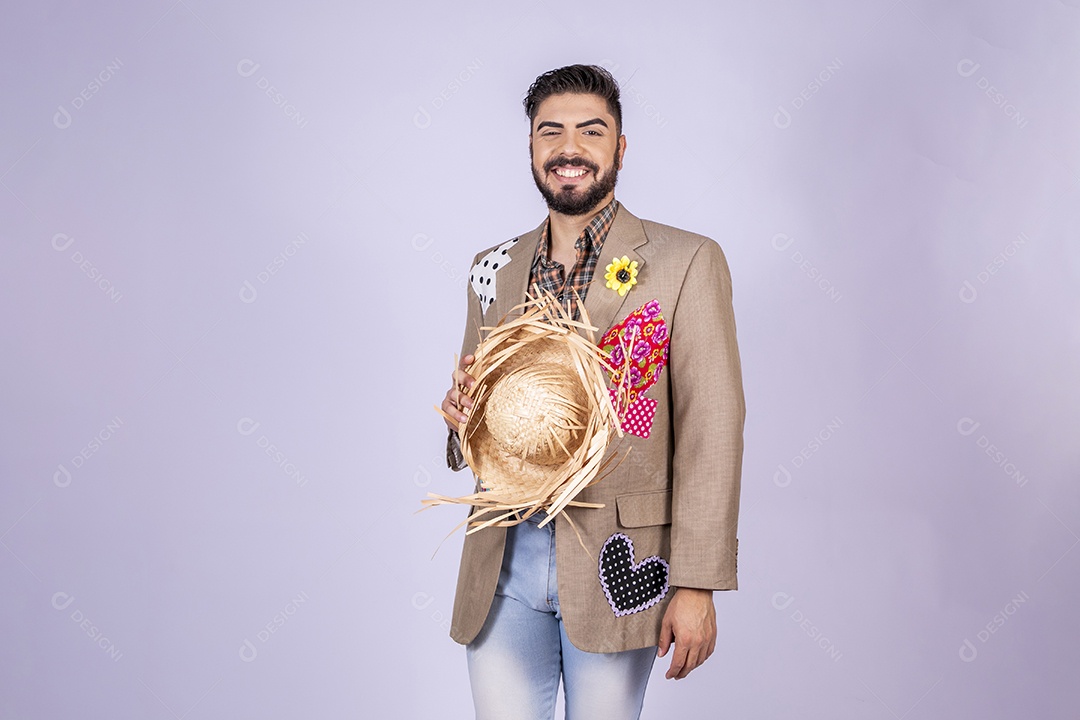 Jovem quadrilheiro animado para festa junina com chapéu nas mãos