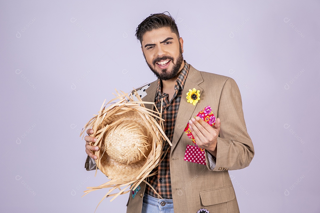 Jovem quadrilheiro animado para festa junina com chapéu na mão e feliz