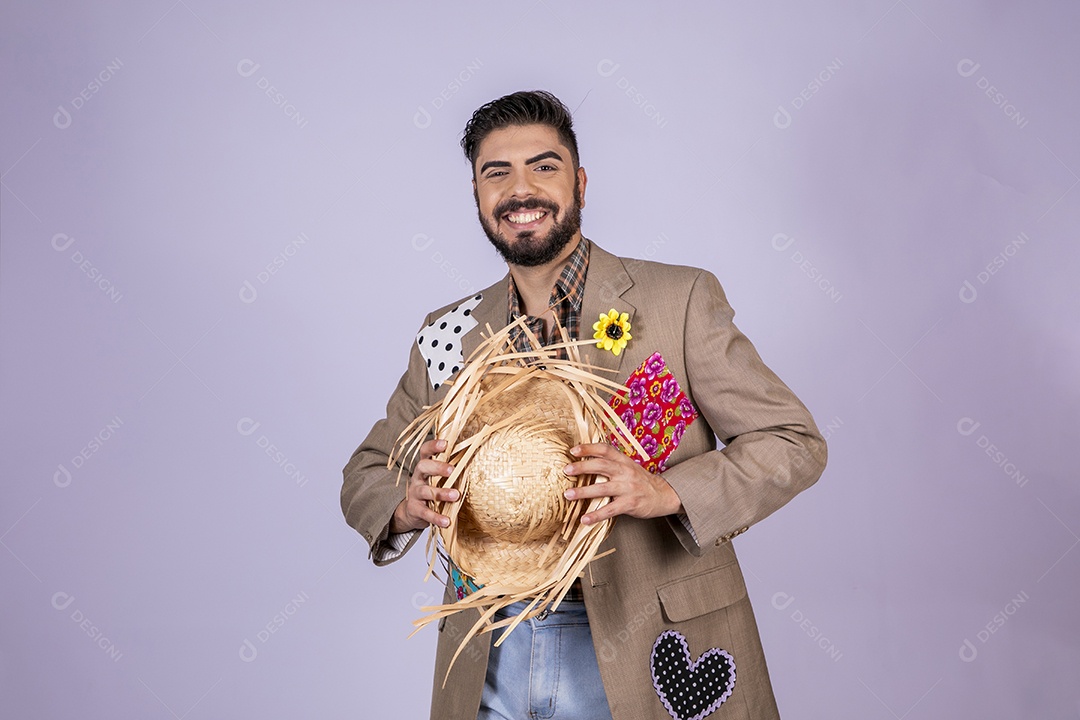 Jovem quadrilheiro animado para festa junina com chapéu nas mãos