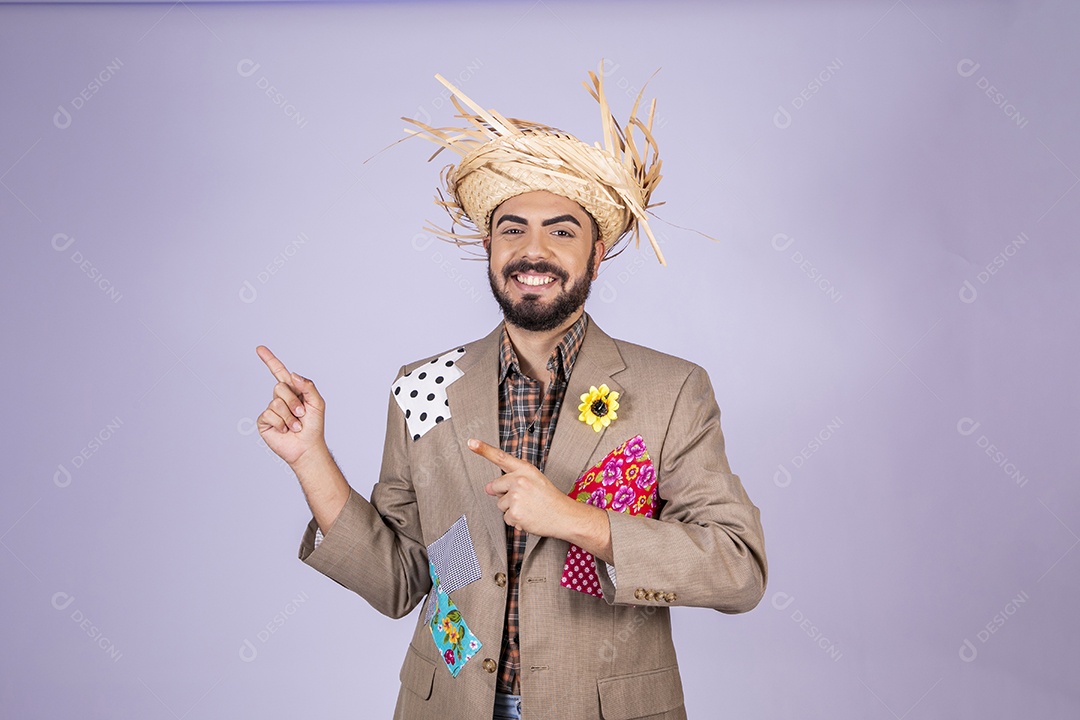 Jovem quadrilheiro animado para festa junina apontando para o lado